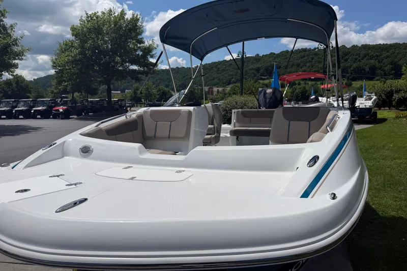 Slide: The Image of 2026 Tahoe 1950 boat with canopy, parked outdoors on a sunny day. - 16