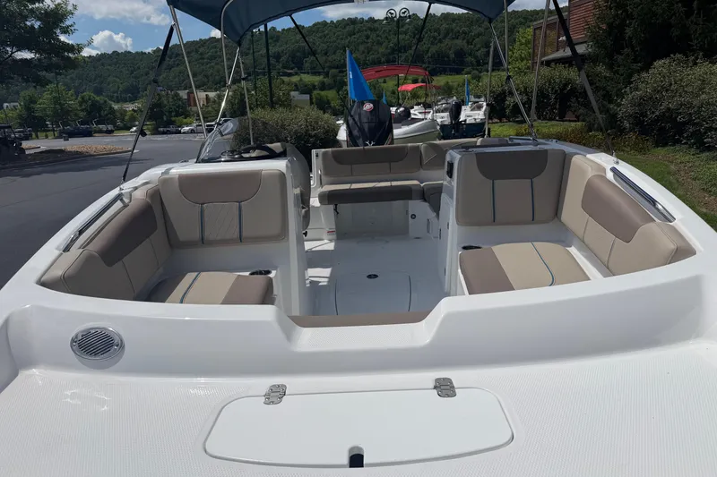 Slide: The Image of 2026 Tahoe 1950 boat interior with beige seating, canopy, and scenic background. - 17