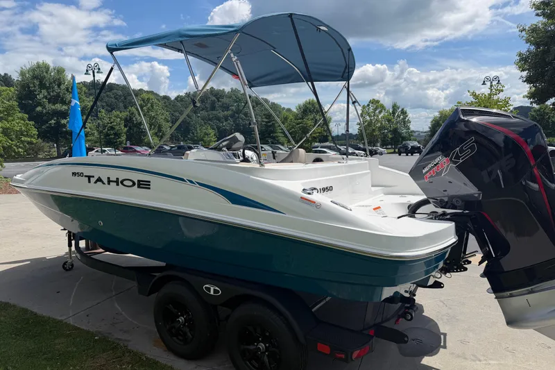 Slide: The Image of 2026 Tahoe 1950 boat with canopy and Mercury Pro XS engine, parked outdoors. - 4