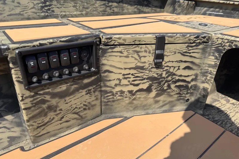 Slide: The Image of 2026 Tracker Grizzly 1756 T Marsh boat interior with control panel and camouflage design. - 8