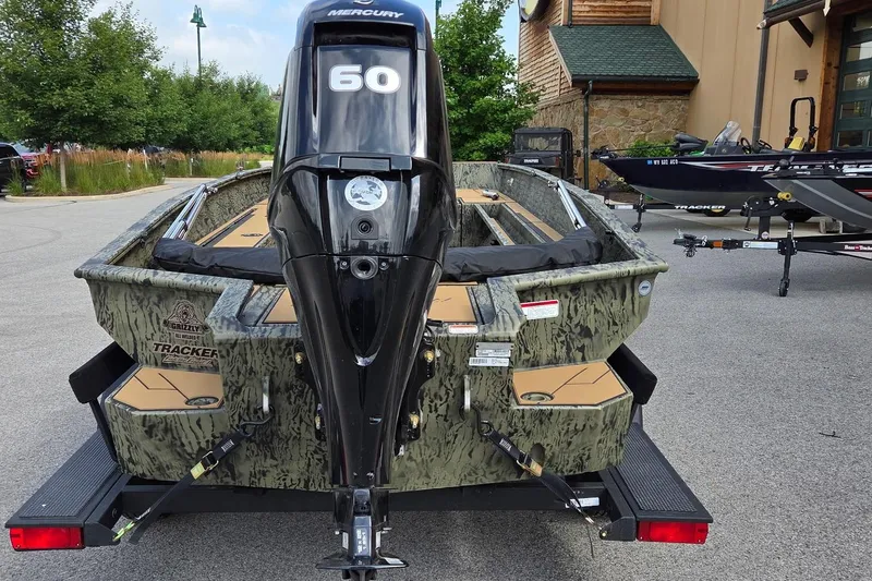 Slide: The Image of 2026 Tracker Grizzly 1756 T Marsh boat with Mercury 60 engine, parked outdoors. - 2