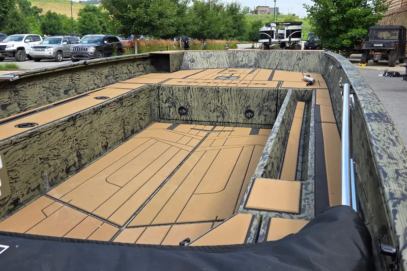 Slide: The Image of 2026 Tracker Grizzly 1756 T Marsh boat with camouflage interior, parked outdoors. - 4
