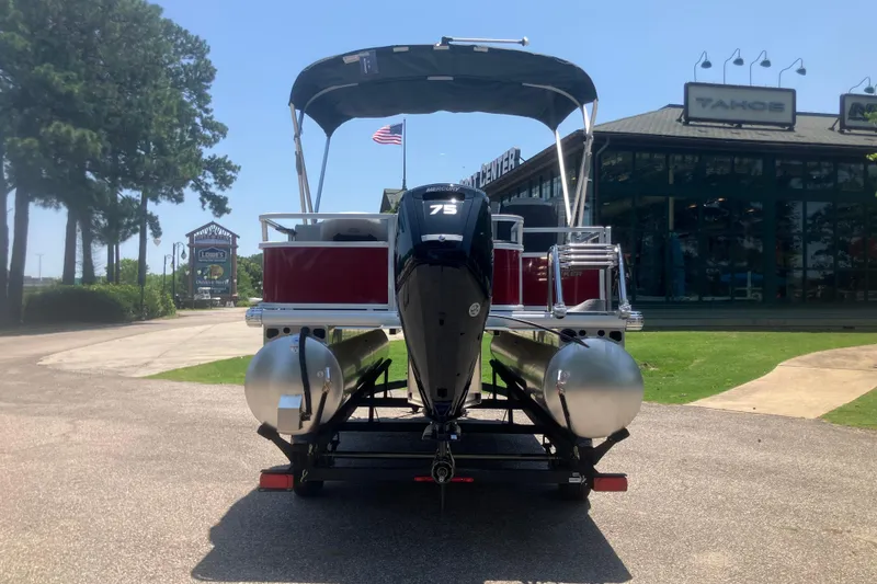 Slide: The Image of 2026 Sun Tracker Bass Buggy 18 DLX pontoon boat with canopy, parked outdoors. - 2