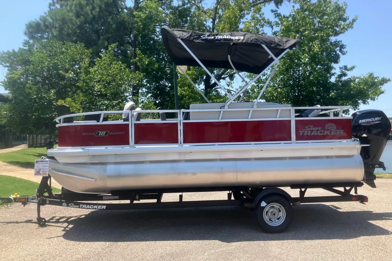 The Image of 2026 Sun Tracker Bass Buggy 18 DLX pontoon boat on trailer, parked outdoors. - 0