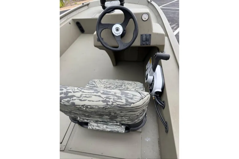 Slide: The Image of 2026 Tracker Grizzly 1754 SC boat interior with camo seat and steering console. - 8
