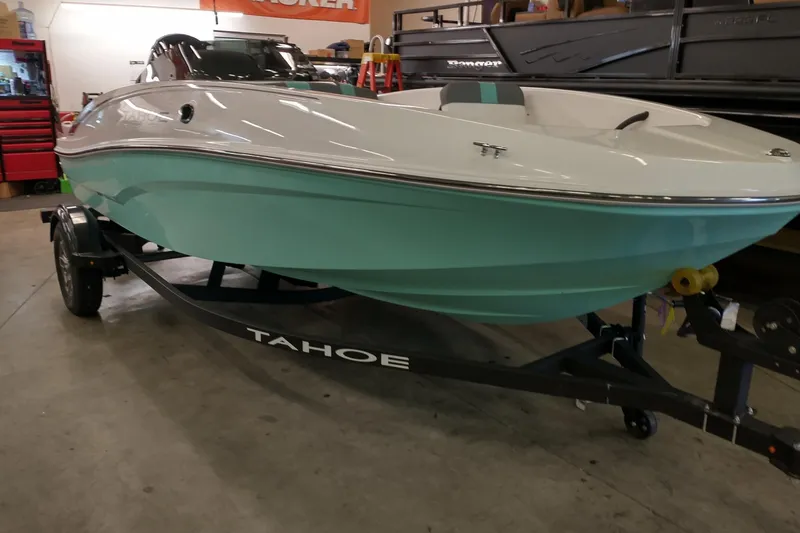 The Image of 2026 Tahoe T16 boat with a sleek design on a trailer in a showroom. - 0