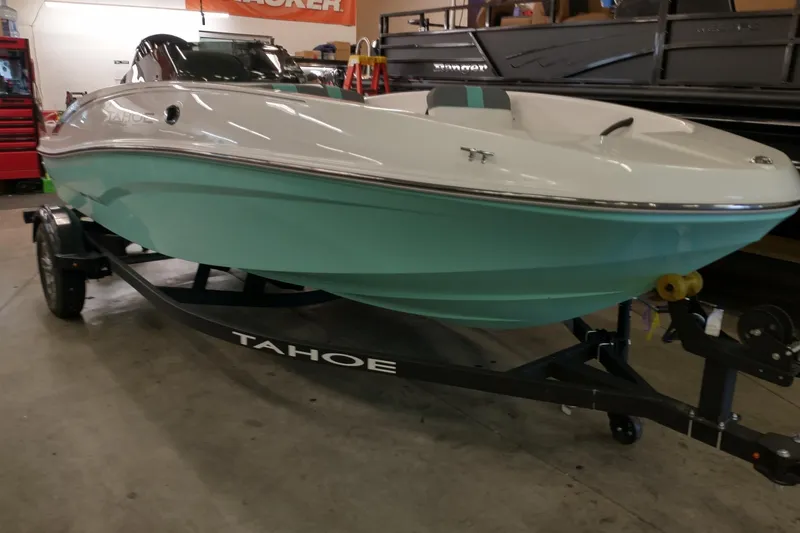 Slide: The Image of 2026 Tahoe T16 boat in showroom, mint green hull, on trailer. - 1