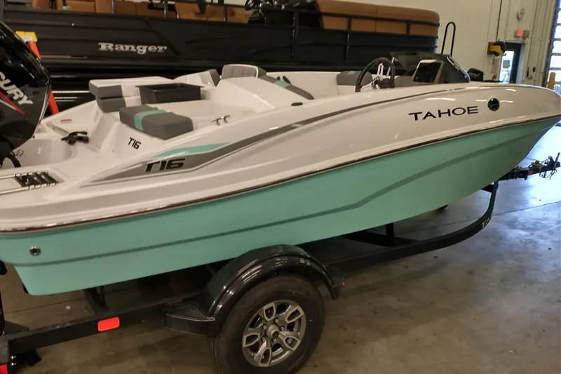 Slide: The Image of 2026 Tahoe T16 boat with sleek design on a trailer in a showroom. - 2