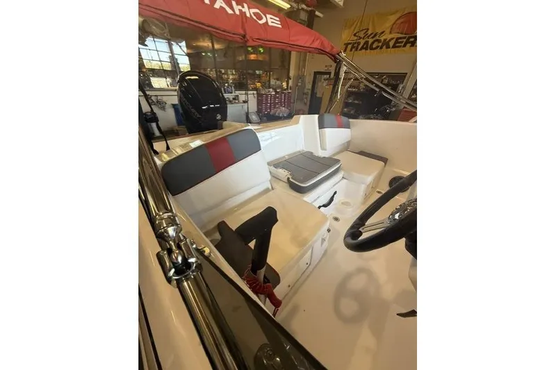 Slide: The Image of 2026 Tahoe T16 boat interior with seating and steering wheel in showroom. - 7