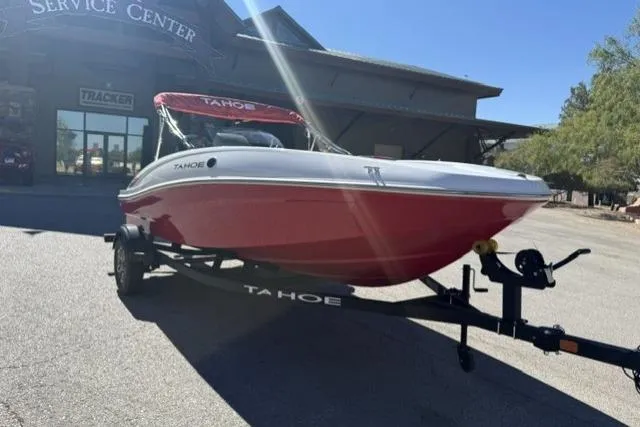 Slide: The Image of 2026 Tahoe T16 boat on trailer outside service center, red and white design. - 68