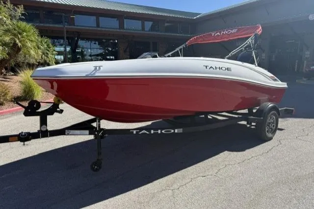 The Image of 2026 Tahoe T16 boat in red and white on a trailer, parked outdoors. - 0