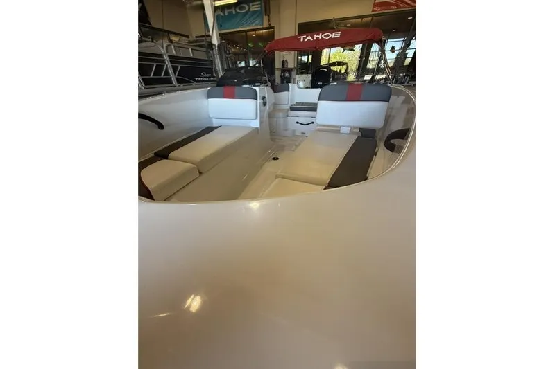 Slide: The Image of 2026 Tahoe T16 boat interior with seating and red canopy in showroom. - 8