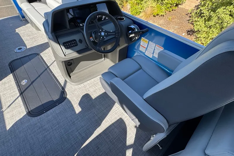 Slide: The Image of Interior view of 2026 Sun Tracker Party Barge 22 XP3, featuring steering console and seating. - 12