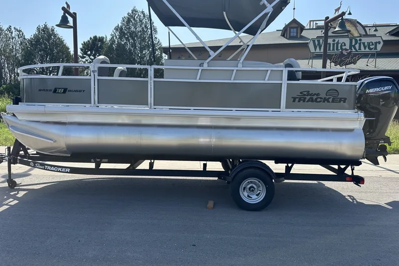 The Image of 2026 Sun Tracker Bass Buggy 18 DLX pontoon boat with Mercury engine on trailer. - 0