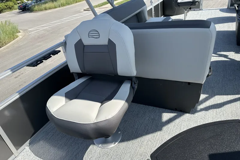 Slide: The Image of 2026 Sun Tracker Bass Buggy 18 DLX boat seat, gray and white upholstery, outdoor setting. - 24