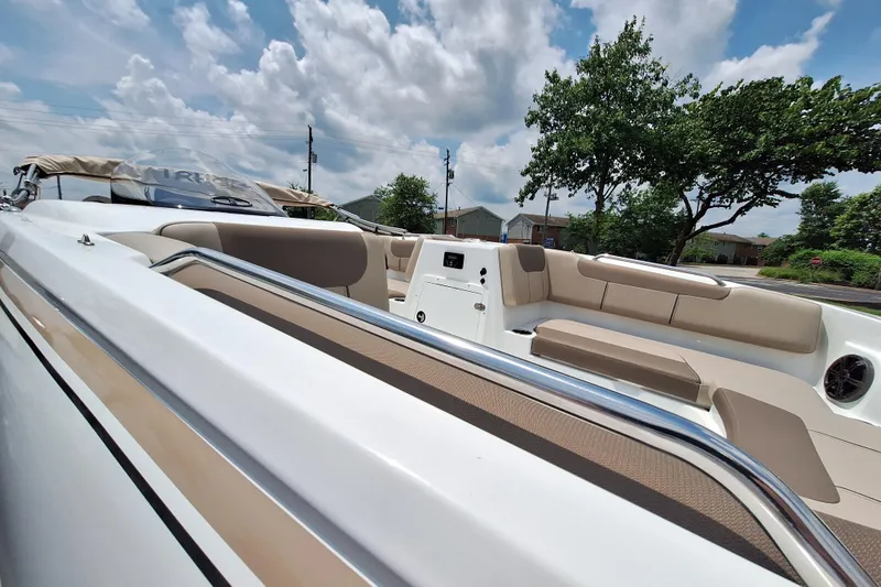 Slide: The Image of 2026 Tahoe 2150 boat interior with beige seating under a partly cloudy sky. - 2