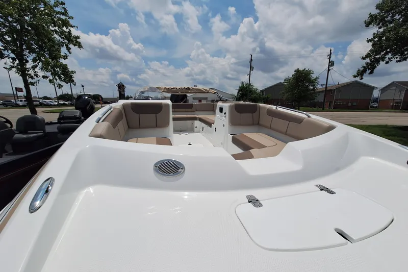 Slide: The Image of 2026 Tahoe 2150 boat with spacious seating, parked outdoors under a cloudy sky. - 5