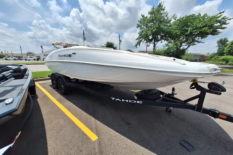 Slide: The Image of 2026 Tahoe 2150 boat on trailer in parking lot under cloudy sky. - 7