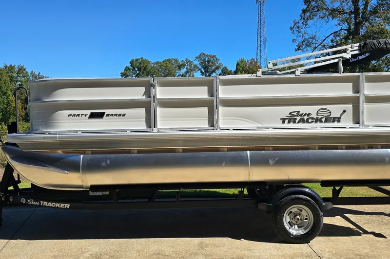 The Image of 2026 Sun Tracker Party Barge 18 DLX pontoon boat on trailer, side view. - 0