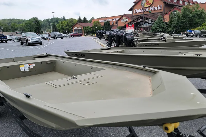 Slide: The Image of 2026 Tracker Grizzly 1754 Utility boats displayed at Outdoor World parking lot. - 2