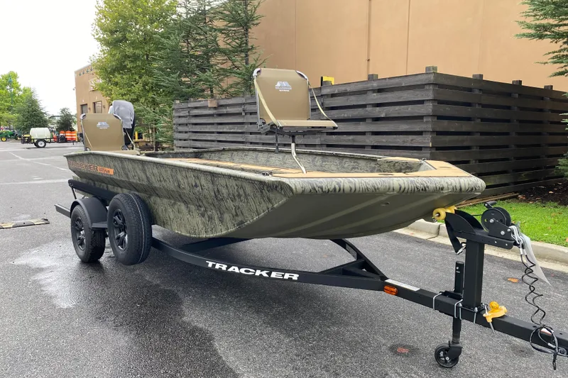 Slide: The Image of 2026 Tracker Grizzly 1756 T Marsh boat on trailer, parked outdoors. - 2