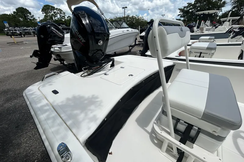 Slide: The Image of 2026 Mako Pro Skiff 17 CC boat with Mercury outboard engine, parked outdoors. - 2