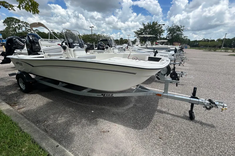 The Image of 2026 Mako Pro Skiff 17 CC boat on trailer in parking lot under cloudy sky. - 0