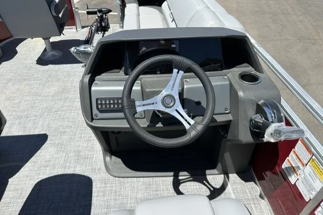 Slide: The Image of 2026 Sun Tracker SportFish 20 DLX boat dashboard with steering wheel and control panel. - 24