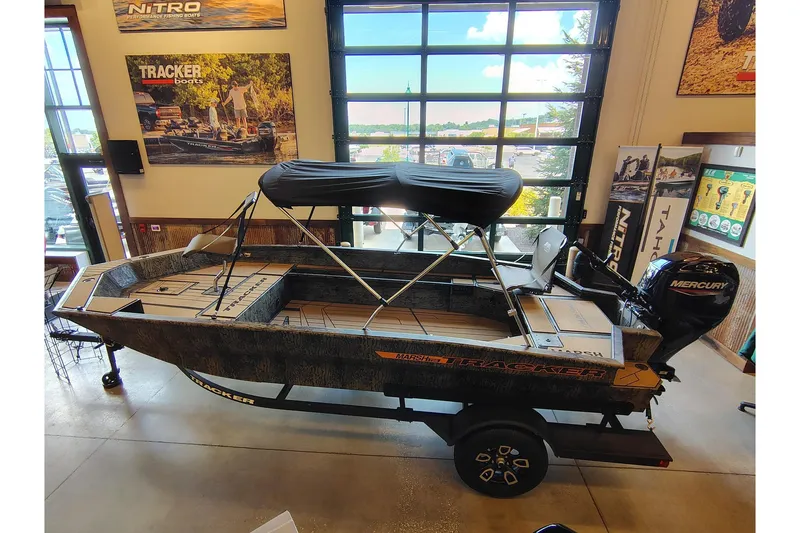 The Image of 2026 Tracker Grizzly 1756 T Marsh boat displayed indoors with Mercury engine. - 0