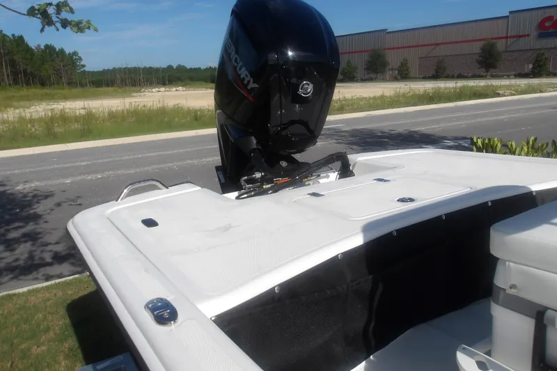 Slide: The Image of 2026 Mako Pro Skiff 17 CC boat with Mercury outboard motor, parked near a road. - 10