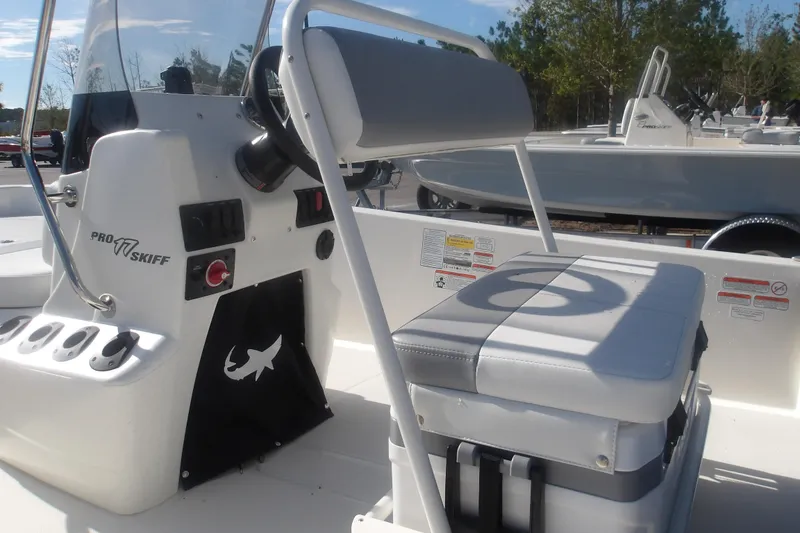 Slide: The Image of 2026 Mako Pro Skiff 17 CC boat interior with steering console and cushioned seating. - 15