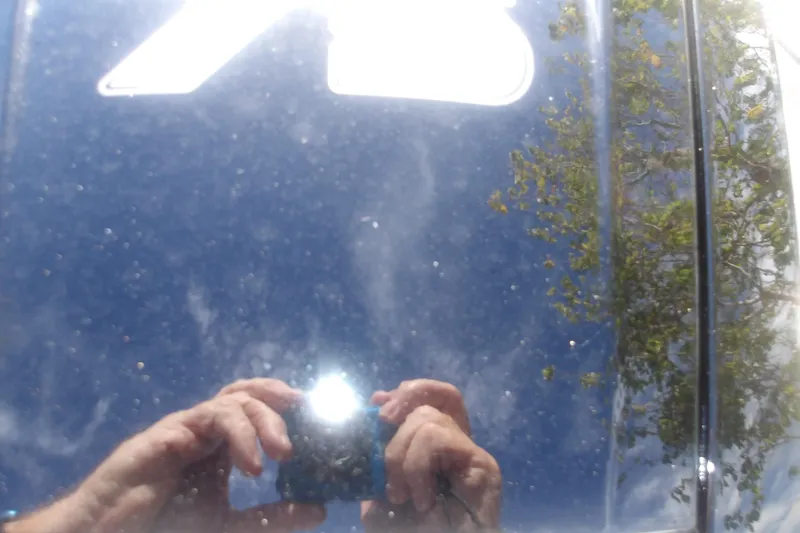 Slide: The Image of Reflection on Mako Pro Skiff 17 CC 2026, capturing sky and trees. - 16