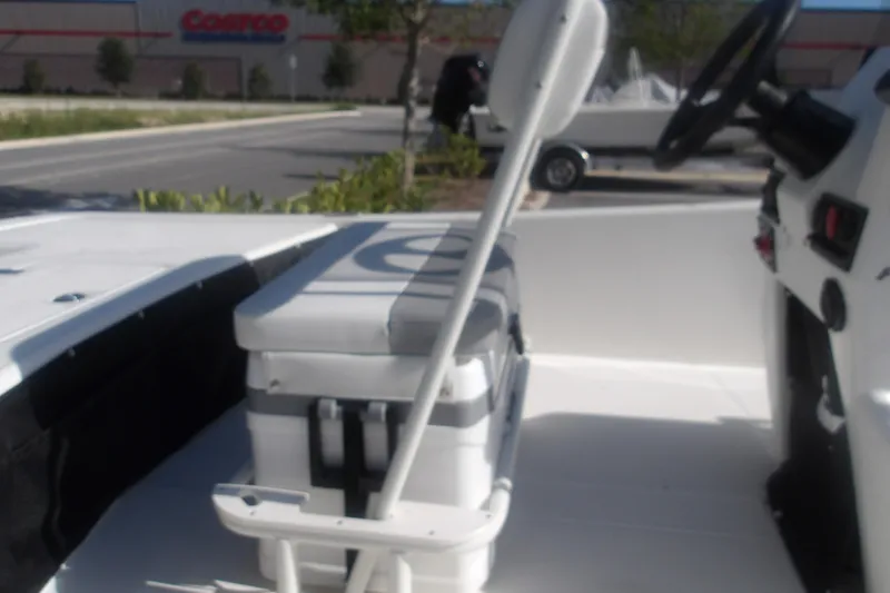 Slide: The Image of 2026 Mako Pro Skiff 17 CC boat interior with seating, parked near a Costco. - 8