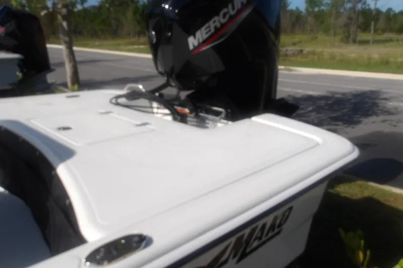 Slide: The Image of 2026 Mako Pro Skiff 17 CC boat with Mercury outboard motor in a parking area. - 13