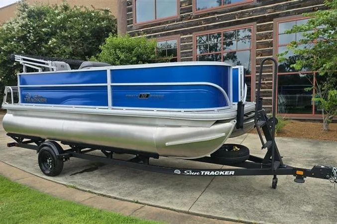 Slide: The Image of 2026 Sun Tracker Party Barge 18 DLX pontoon boat on trailer, parked outdoors. - 6