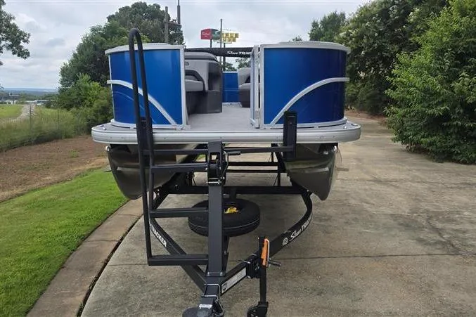 Slide: The Image of 2026 Sun Tracker Party Barge 18 DLX pontoon boat on trailer, parked outdoors. - 2