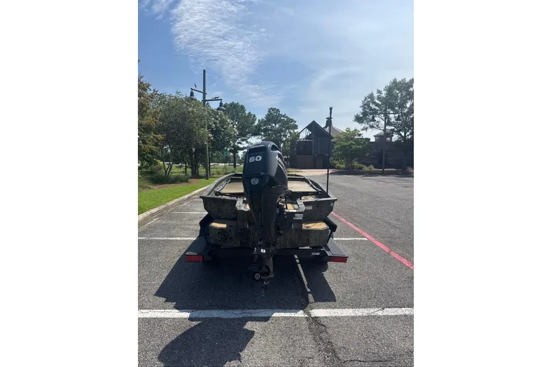 Slide: The Image of 2026 Tracker Grizzly 1756 T Marsh boat with outboard motor in parking lot. - 3