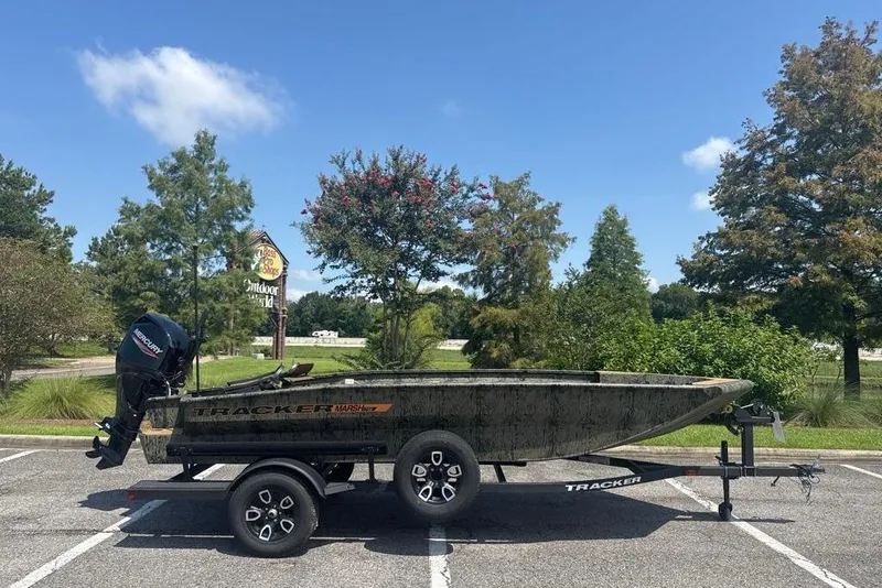 The Image of 2026 Tracker Grizzly 1756 T Marsh boat on trailer in parking lot, sunny day. - 0