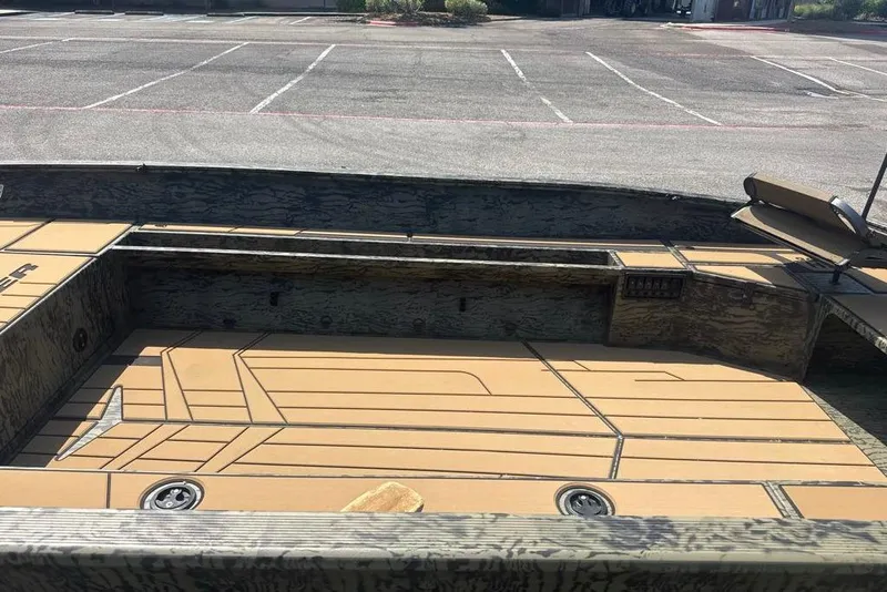 Slide: The Image of 2026 Tracker Grizzly 1756 T Marsh boat interior with tan deck in a parking lot. - 5