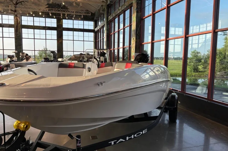 Slide: The Image of 2026 Tahoe T16 boat displayed indoors with large windows and scenic view. - 4