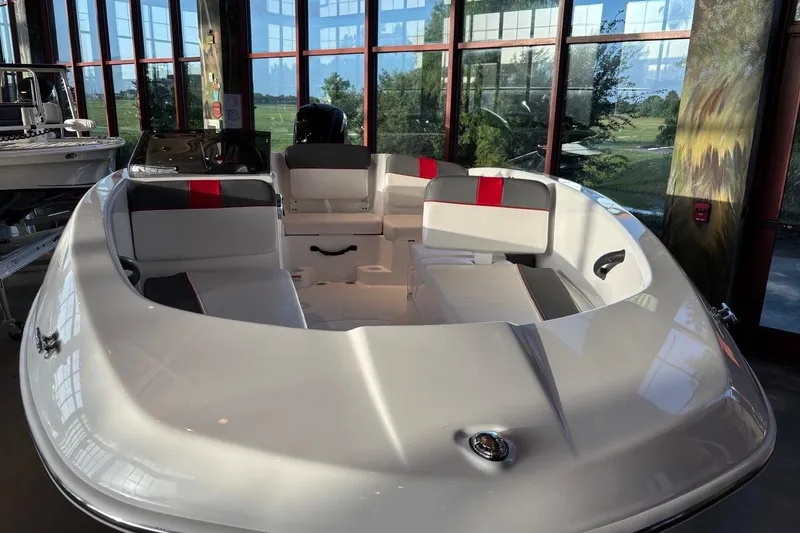 Slide: The Image of 2026 Tahoe T16 boat interior with modern seating, displayed indoors with large windows. - 8