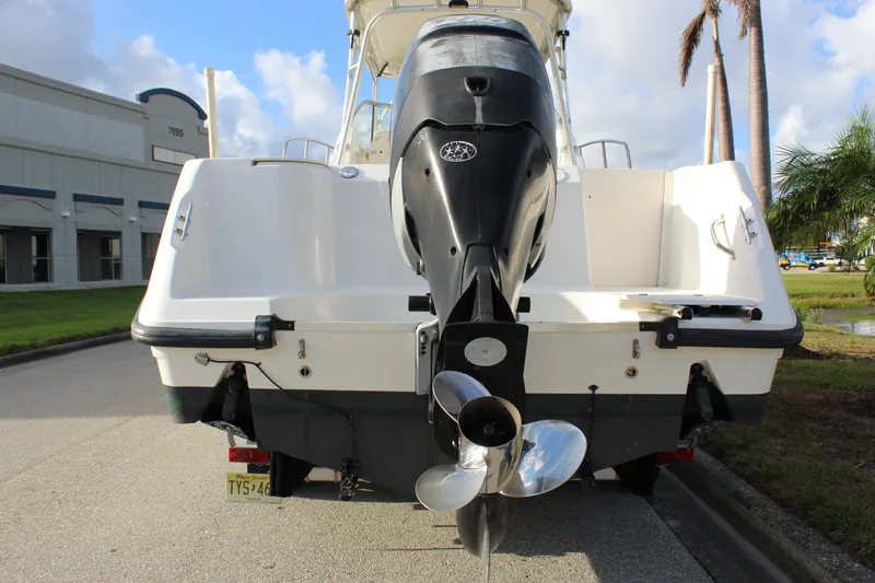 Slide: The Image of 2005 Boston Whaler 255 Conquest boat with powerful outboard motor, parked outdoors. - 11