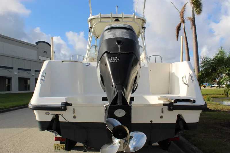 Slide: The Image of 2005 Boston Whaler 255 Conquest boat with outboard motor, parked outdoors. - 15