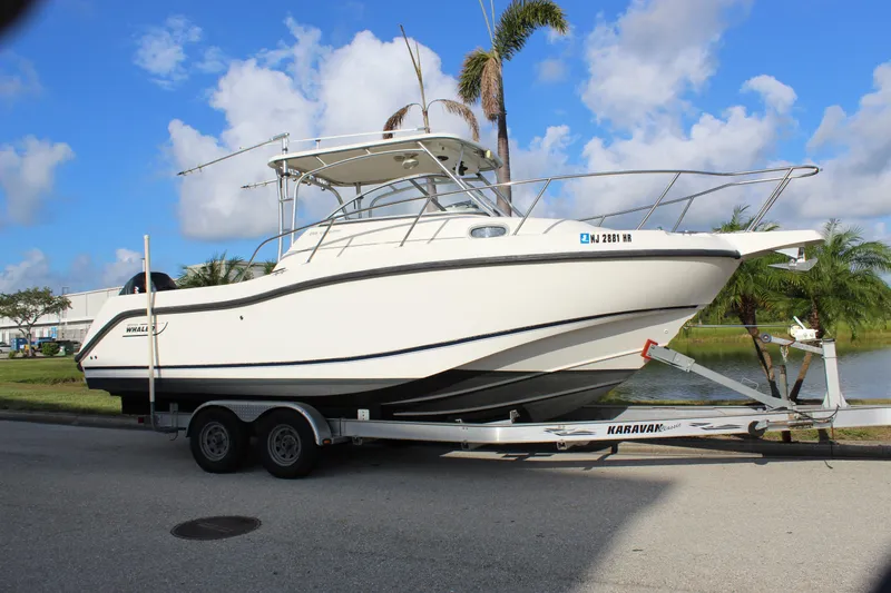 Slide: The Image of 2005 Boston Whaler 255 Conquest boat on trailer, parked near palm trees. - 18