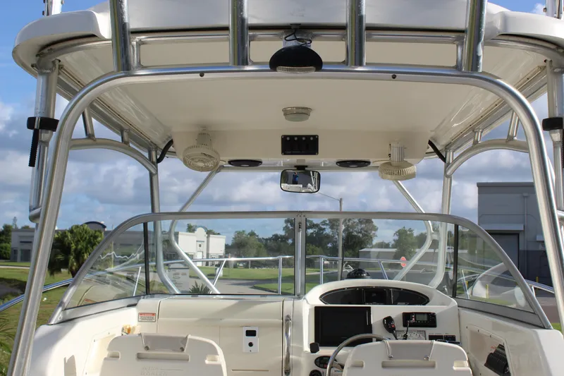 Slide: The Image of 2005 Boston Whaler 255 Conquest boat cockpit with steering wheel and navigation equipment. - 32