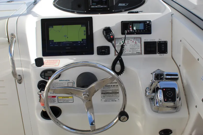 Slide: The Image of Control panel of a 2005 Boston Whaler 255 Conquest boat with steering wheel and navigation equipment. - 37