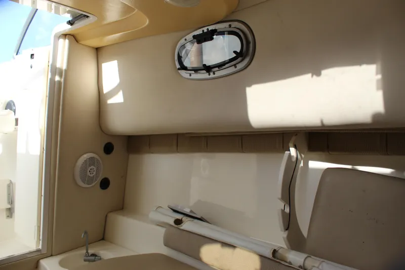 Slide: The Image of Interior cabin of 2005 Boston Whaler 255 Conquest boat, featuring seating and a small window. - 43