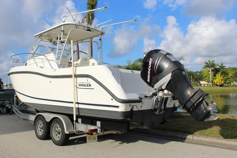 Slide: The Image of 2005 Boston Whaler 255 Conquest boat on trailer, featuring Mercury outboard motor. - 8