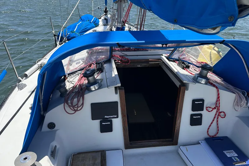 Slide: The Image of 1982 C&C 34 sailboat cockpit with blue canopy and nautical equipment. - 13