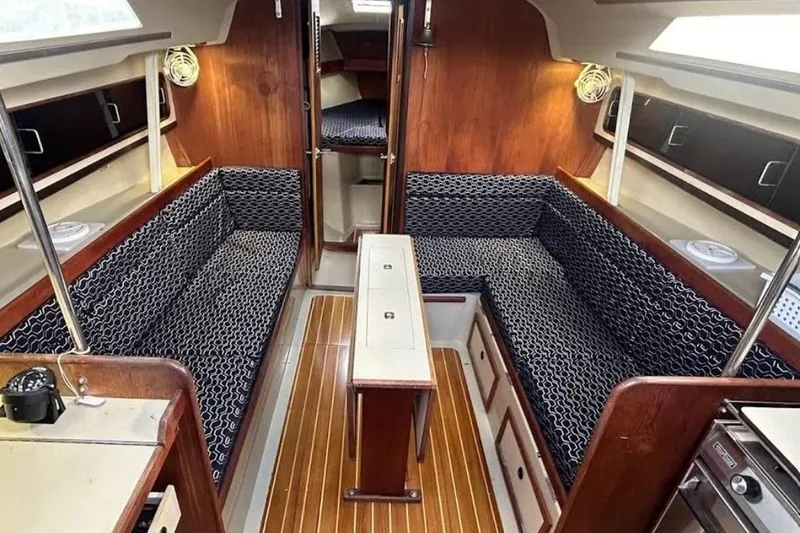 Slide: The Image of Interior of a 1982 C&C 34 sailboat with wood paneling and patterned seating. - 16